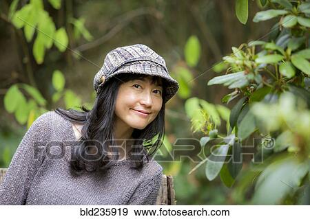 Stock Photo - Portrait of smiling Japanese woman in forest. Fotosearch