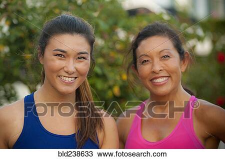 Stock Image - Portrait of smiling Mixed Race mother and daughter. Fotosearch