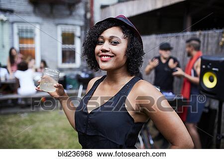 Stock Photo - Portrait of smiling Mixed Race woman at backyard party. Fotosearch