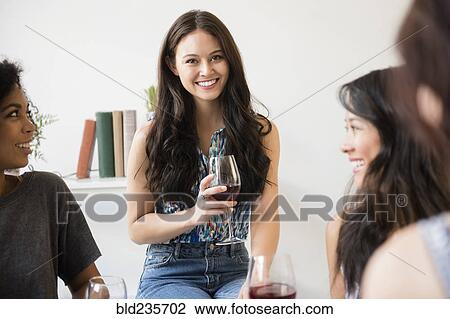 Portrait of smiling woman drinking wine at party View Large Photo Image Stock Image - Portrait of smiling woman drinking wine at party. Fotosearch