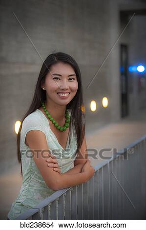 Picture - Portrait of smiling woman leaning on railing. Fotosearch