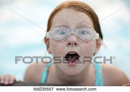 Stock Photo - Portrait of surprised Caucasian girl wearing swimming goggles. Fotosearch