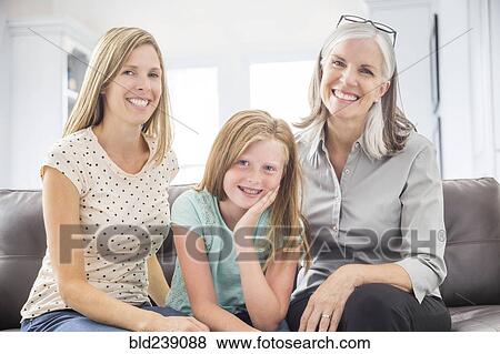 Stock Photo - Portrait of women and girl sitting on sofa. Fotosearch