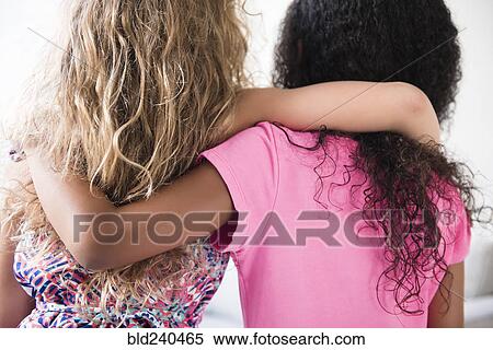 Stock Photography - Rear view of girls hugging. Fotosearch
