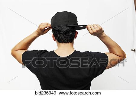Rear view of Hispanic man adjusting baseball cap View Large Photo Image Stock Photo - Rear view of Hispanic man adjusting baseball cap. Fotosearch
