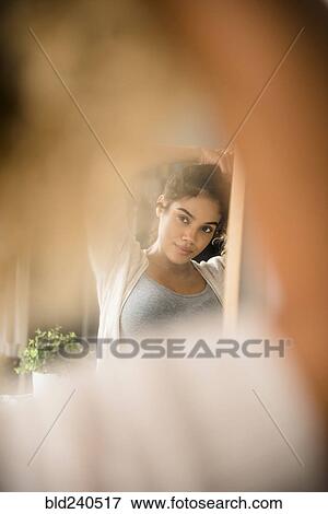 Reflection in mirror of Mixed Race woman holding hair View Large Photo Image Stock Photo - Reflection in mirror of Mixed Race woman holding hair. Fotosearch