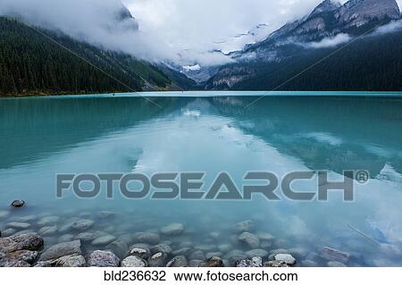 Reflection of clouds in still mountain lake View Large Photo Image Stock Image - Reflection of clouds in still mountain lake. Fotosearch
