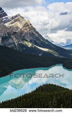 Stock Photo - Reflection of clouds in still mountain lake. Fotosearch