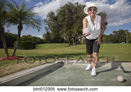 Stock Photography - Senior Caucasian woman playing bocce ball. Fotosearch
