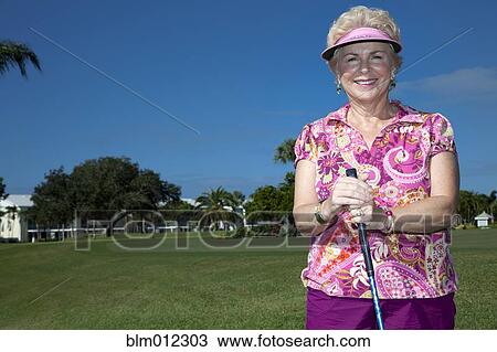 Stock Image - Senior Caucasian woman playing golf. Fotosearch