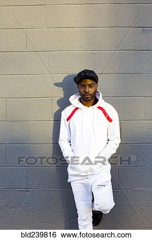 Serious Black man leaning on gray wall View Large Photo Image Stock Photograph - Serious Black man leaning on gray wall. Fotosearch