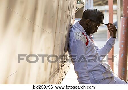 Stock Photograph - Serious Black man leaning on truck. Fotosearch