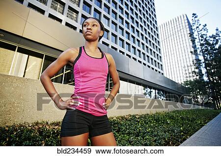Serious Black woman standing on city sidewalk View Large Photo Image Stock Photo - Serious Black woman standing on city sidewalk. Fotosearch