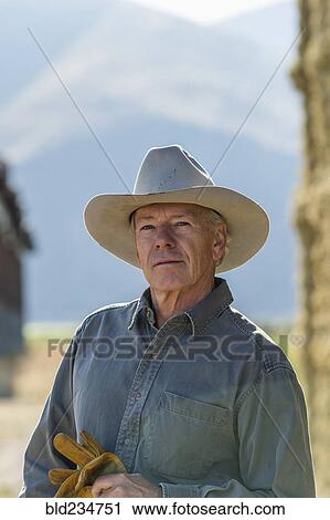 Serious Caucasian farmer holding gloves View Large Photo Image Stock Image - Serious Caucasian farmer holding gloves. Fotosearch