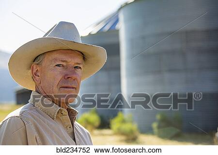 Serious Caucasian farmer near storage silos View Large Photo Image Stock Image - Serious Caucasian farmer near storage silos. Fotosearch
