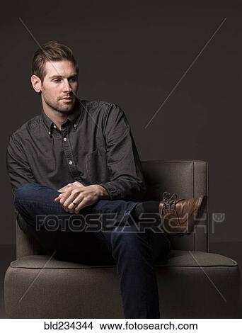 Serious Caucasian man sitting in armchair View Large Photo Image Picture - Serious Caucasian man sitting in armchair. Fotosearch