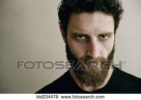 Serious Caucasian man with beard looking at camera View Large Photo Image Stock Photo - Serious Caucasian man with beard looking at camera. Fotosearch