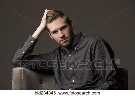 Stock Photography - Serious Caucasian man with hand in hair. Fotosearch