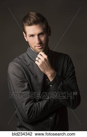 Stock Image - Serious Caucasian man with hand on chin. Fotosearch