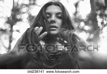 Stock Image - Serious Caucasian woman with hands in hair. Fotosearch