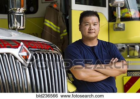 Serious Chinese fireman posing with fire truck View Large Photo Image Stock Photograph - Serious Chinese fireman posing with fire truck. Fotosearch