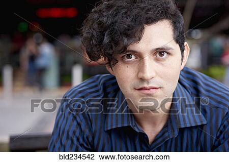 Serious Hispanic man with curly hair View Large Photo Image Stock Image - Serious Hispanic man with curly hair. Fotosearch