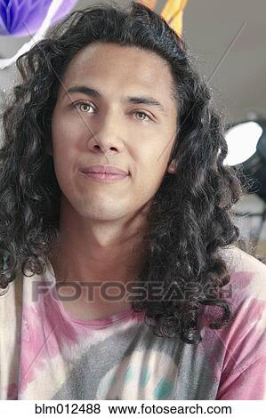 Serious Hispanic Man With Long Curly Hair Stock Photo