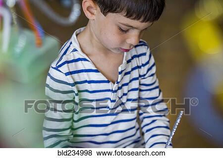 Stock Photo - Serious mixed race boy looking down. Fotosearch