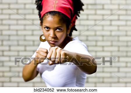 Stock Image - Serious Mixed Race woman posing with fists. Fotosearch