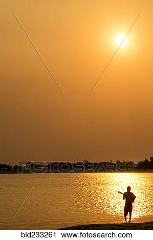 Silhouette of Caucasian man playing guitar at beach at sunset View Large Photo Image Stock Image - Silhouette of Caucasian man playing guitar at beach at sunset. Fotosearch