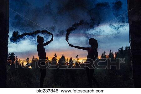 Silhouette of women holding smoking flares View Large Photo Image Stock Photograph - Silhouette of women holding smoking flares. Fotosearch
