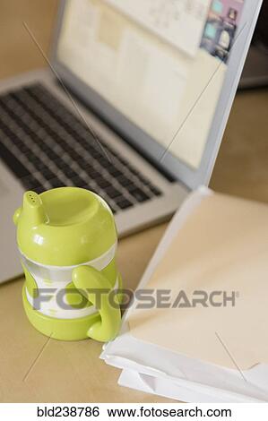 Sippy cup near file folder and laptop View Large Photo Image Stock Photograph - Sippy cup near file folder and laptop. Fotosearch