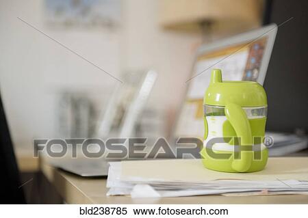 Sippy cup on file folder near laptop View Large Photo Image Stock Photography - Sippy cup on file folder near laptop. Fotosearch
