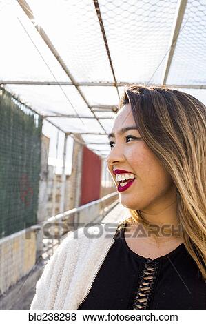 Smiling Asian woman on footbridge View Large Photo Image Stock Photo - Smiling Asian woman on footbridge. Fotosearch