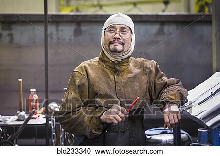Smiling Asian worker wearing hood posing in factory View Large Photo Image Stock Image - Smiling Asian worker wearing hood posing in factory. Fotosearch