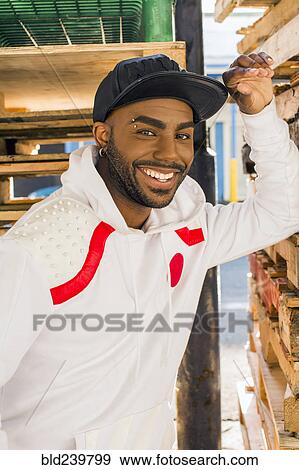 Smiling Black man leaning on wooden pallets View Large Photo Image Stock Photo - Smiling Black man leaning on wooden pallets. Fotosearch
