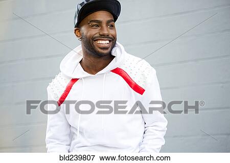 Stock Photo - Smiling Black man near gray wall. Fotosearch