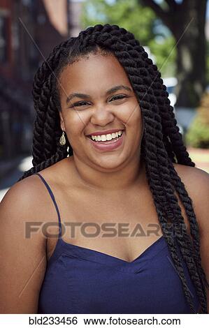 Stock Photograph - Smiling Black woman laughing in city. Fotosearch