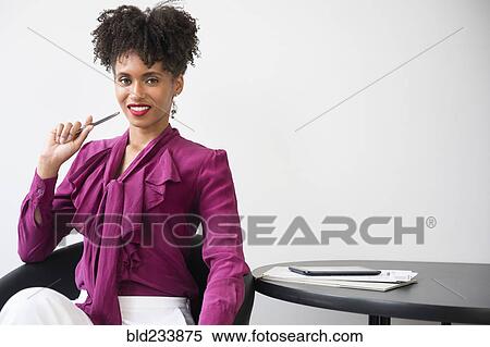 Smiling Black woman wearing purple blouse holding pen View Large Photo Image Stock Photography - Smiling Black woman wearing purple blouse holding pen. Fotosearch