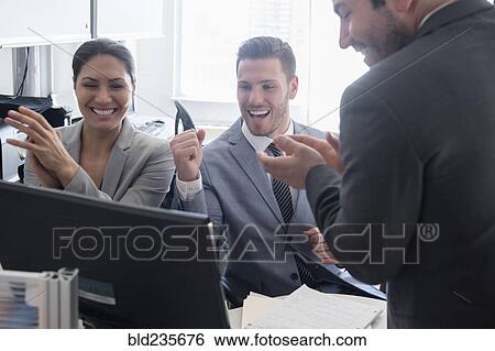 Smiling business people celebrating in office View Large Photo Image Stock Photograph - Smiling business people celebrating in office. Fotosearch