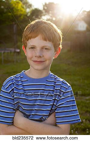 Smiling Caucasian boy standing in sunny backyard View Large Photo Image Stock Image - Smiling Caucasian boy standing in sunny backyard. Fotosearch