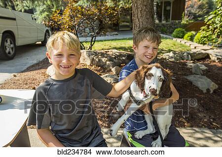Smiling Caucasian boys petting dog View Large Photo Image Picture - Smiling Caucasian boys petting dog. Fotosearch