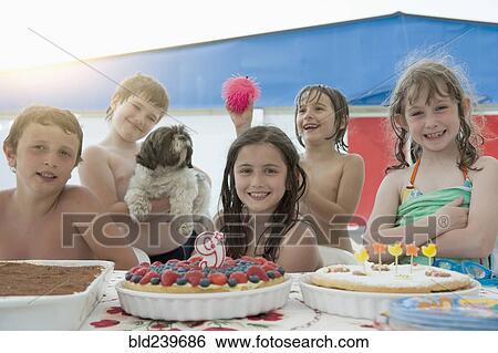 Stock Photograph - Smiling Caucasian children posing at birthday party. Fotosearch