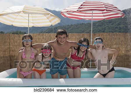 Picture - Smiling Caucasian children posing in inflatable swimming pool. Fotosearch