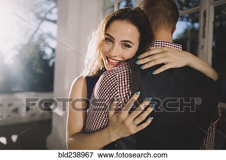 Stock Photo - Smiling Caucasian couple hugging. Fotosearch