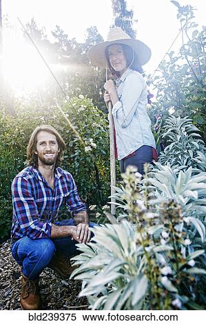Smiling Caucasian couple posing in garden View Large Photo Image Stock Photography - Smiling Caucasian couple posing in garden. Fotosearch