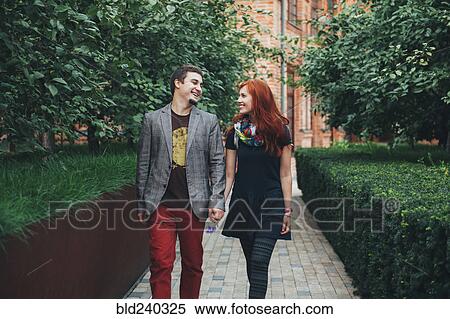 Stock Photography - Smiling Caucasian couple walking in city. Fotosearch