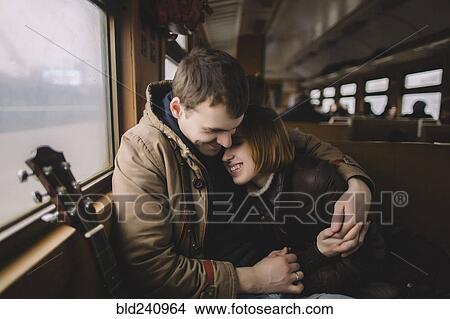 Smiling Caucasian couple with guitar hugging on train View Large Photo Image Picture - Smiling Caucasian couple with guitar hugging on train. Fotosearch