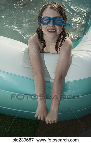 Smiling Caucasian girl in inflatable swimming pool View Large Photo Image Stock Photo - Smiling Caucasian girl in inflatable swimming pool. Fotosearch