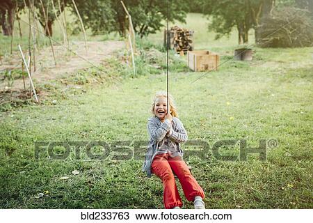 Smiling Caucasian girl on rope swing View Large Photo Image Stock Image - Smiling Caucasian girl on rope swing. Fotosearch